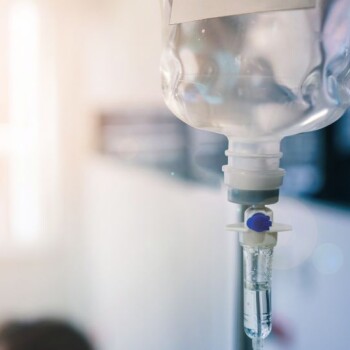 An IV bag with a blue and white toned background.