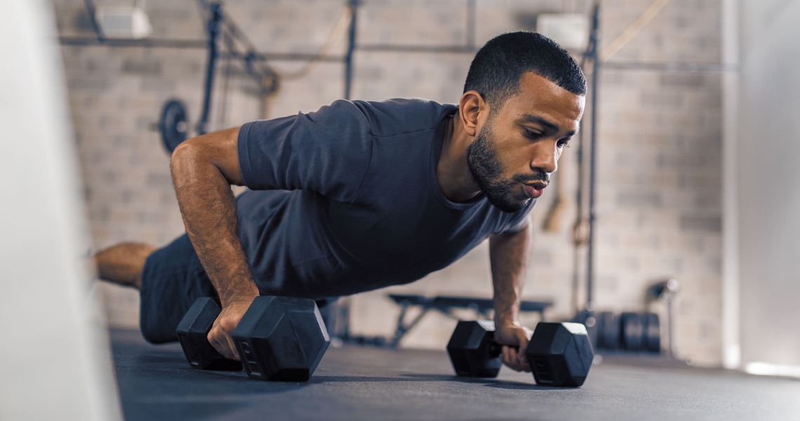 A man doing pushups using weights.