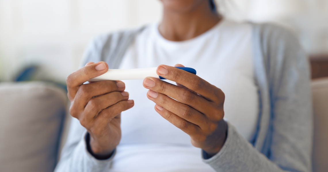 A person holding a pregnancy test.