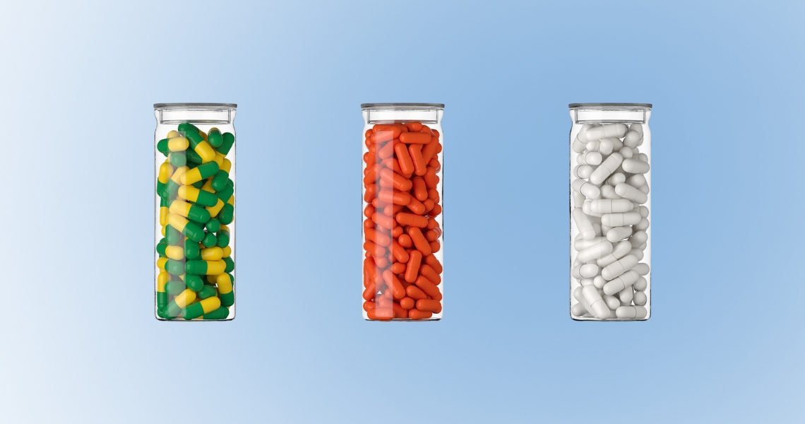 Three clear vials filled with different colored capsules.