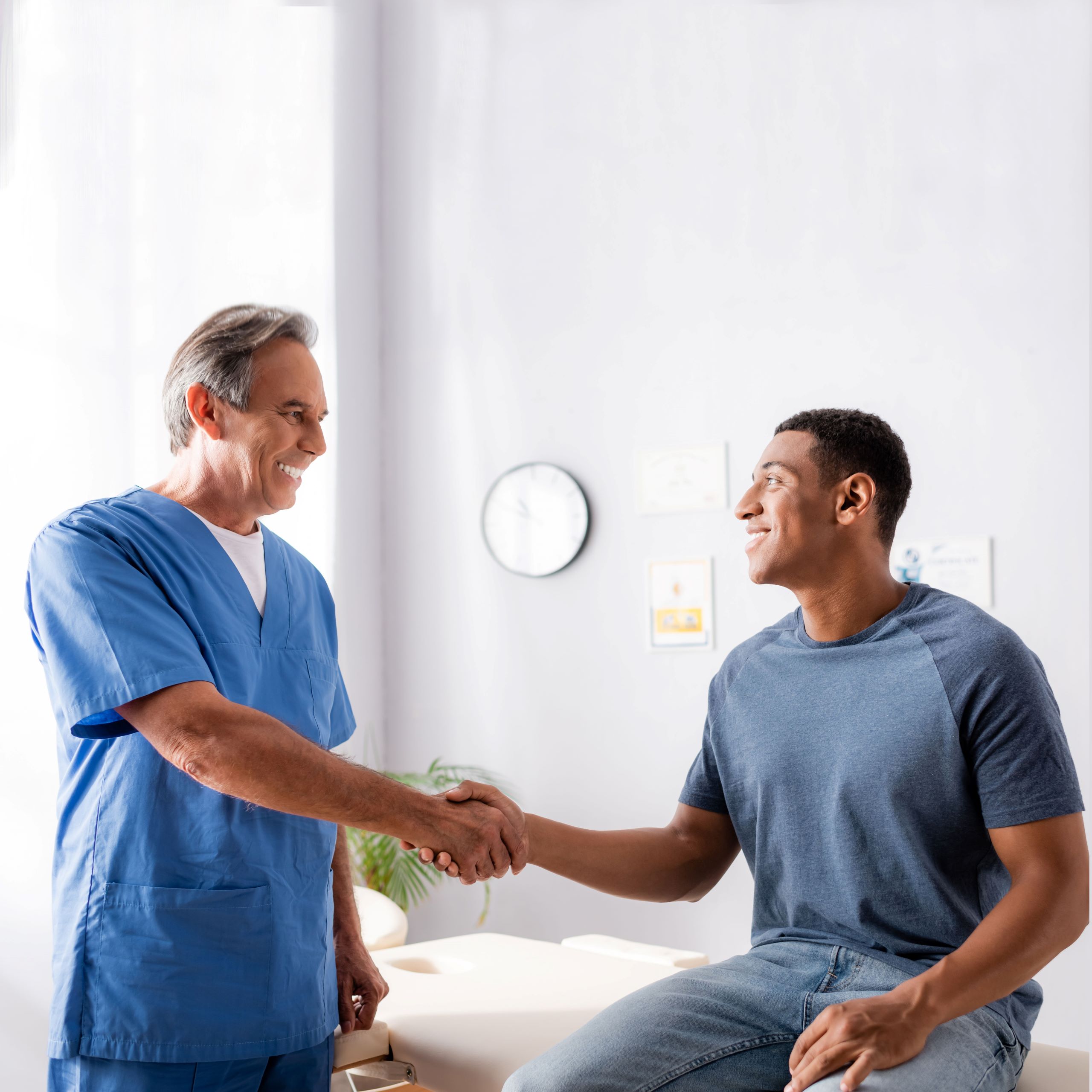 A male provider shaking hands with a male patient.