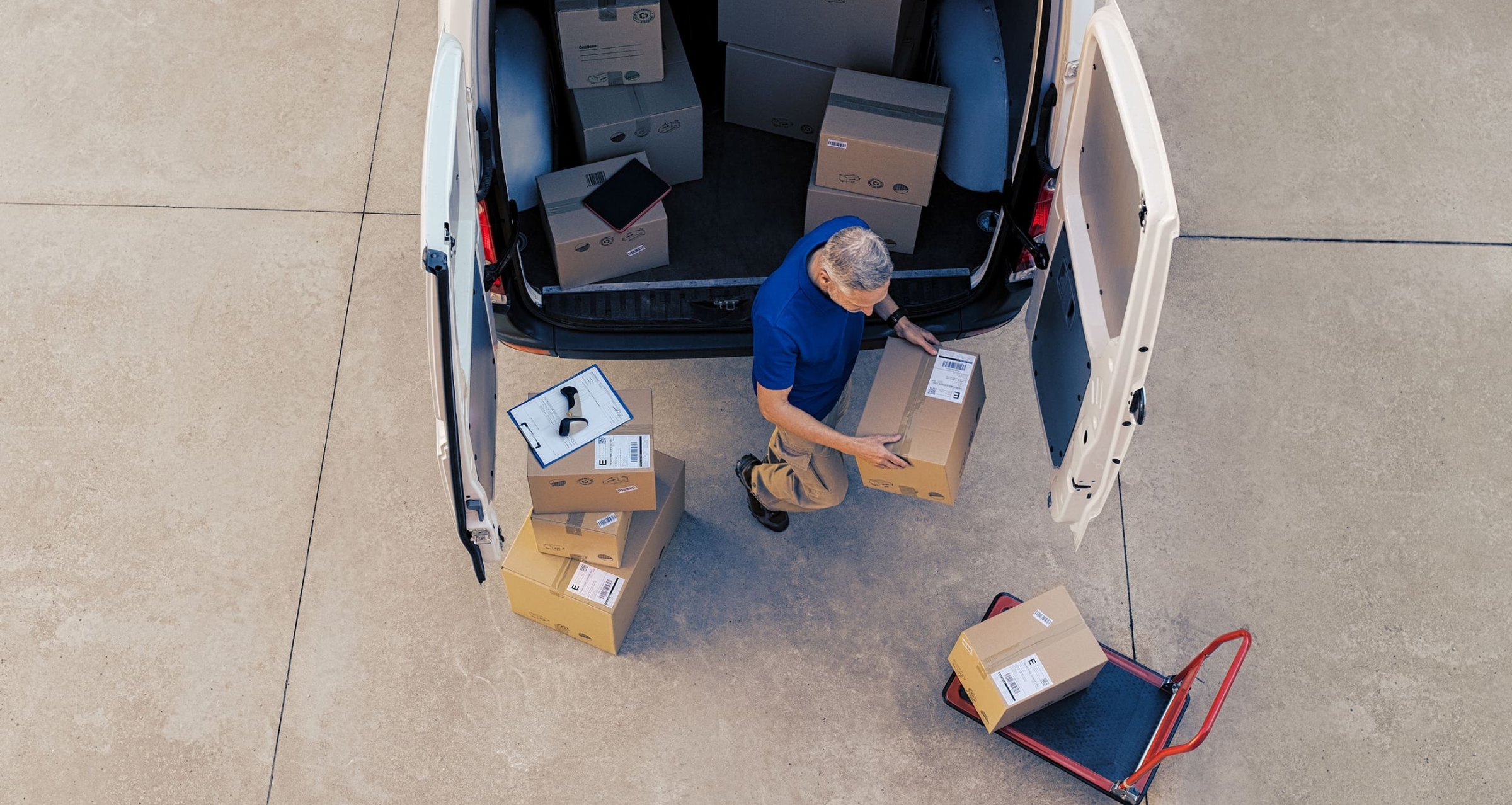 A man loading boxes into the back of a van.