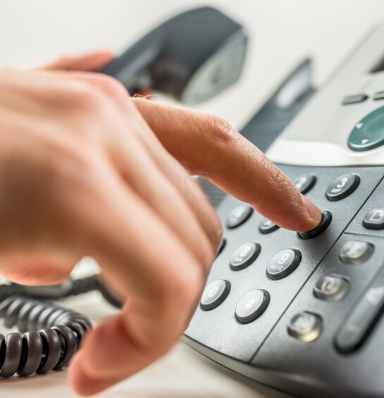 Closeup of male hand dialing a phone number making a business or personal phone call.