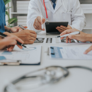 people sitting around a table reviewing medical documentation
