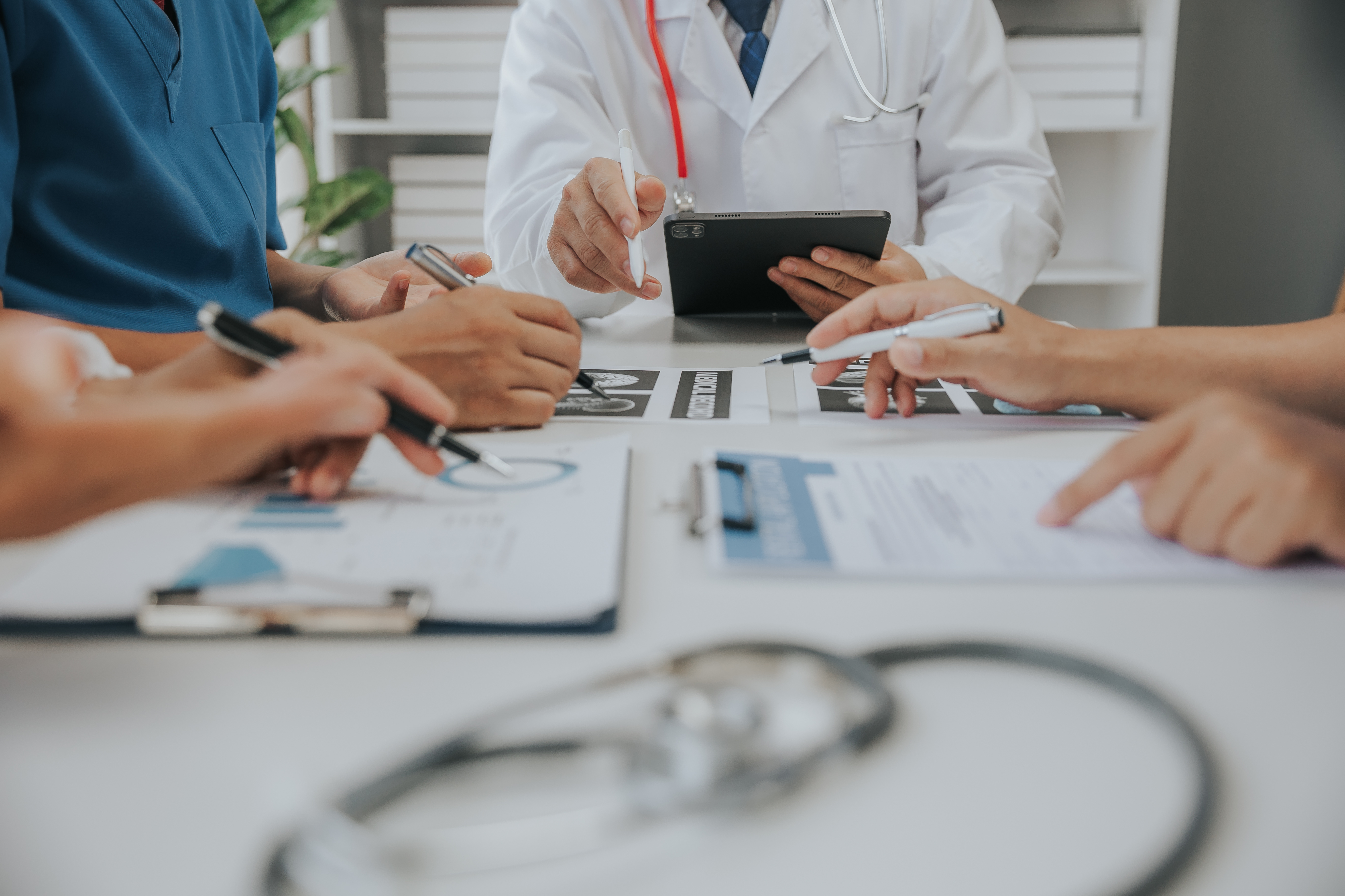 people sitting around a table reviewing medical documentation