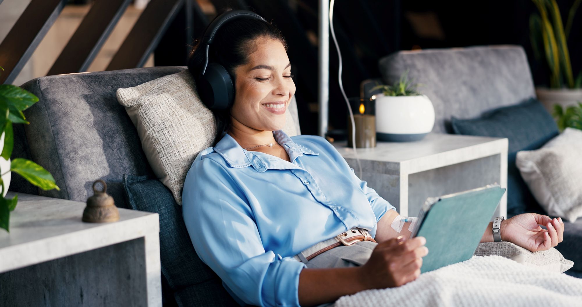 Happy woman, tablet and headphones with IV drip for healthcare, infusion treatment and streaming video.